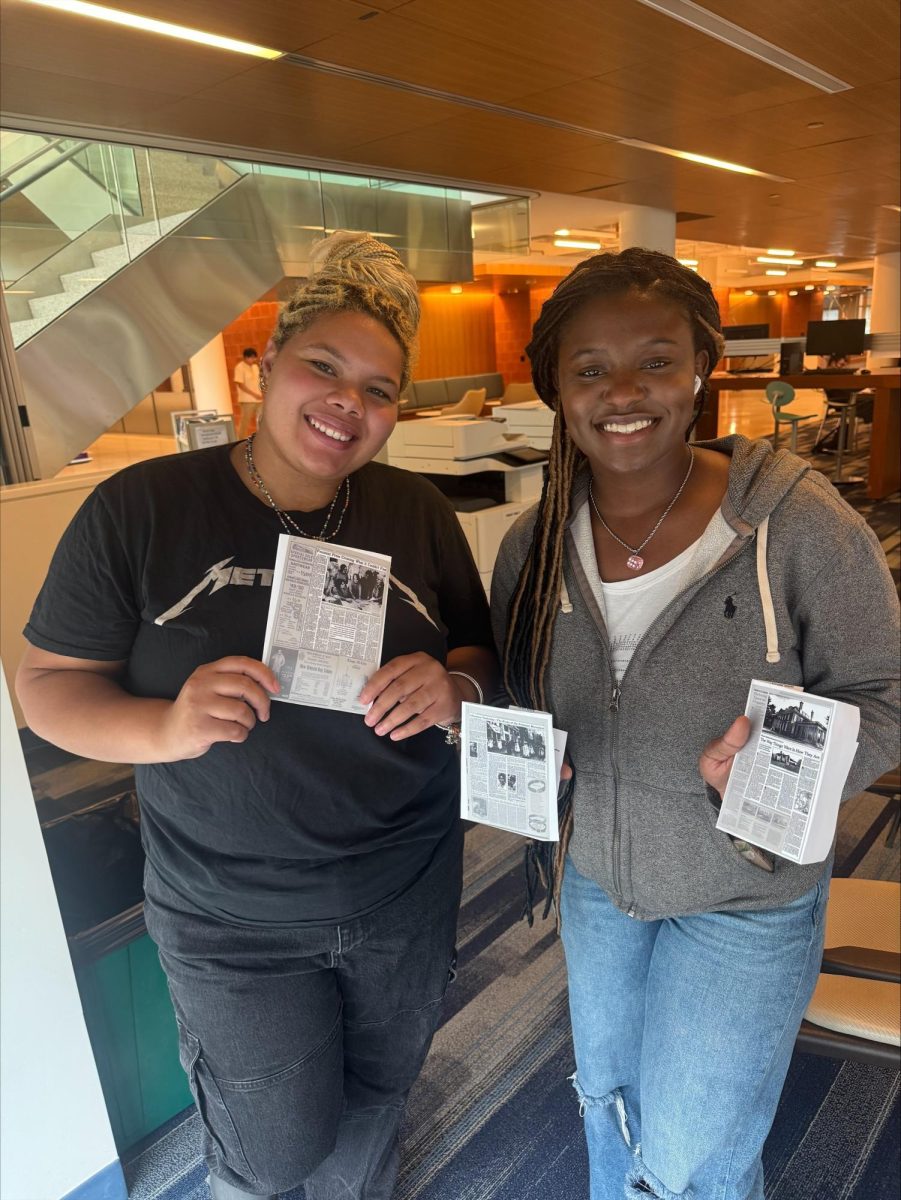 SUNY Old Westbury students hold reproductions of early Feminist Press publications on Sept. 26, 2025, connecting the campus’s activist past to its present-day academic community. PHOTO BY: DESPINA DRAKOPOULOS