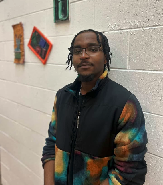 Chevaun Cooper poses for a portrait against a mural-lined wall on March 16, 2026. PHOTO BY: THIERRY SANZ