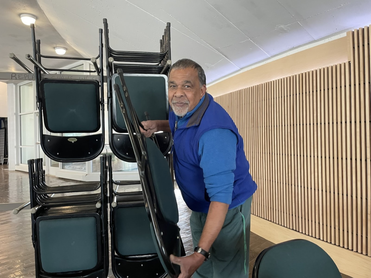 Desmond Lachlan, setting up chairs for a career fair in the SUNY Old Westbury campus center, on April 8, 2026. PHOTO BY: ANN BUNCH 